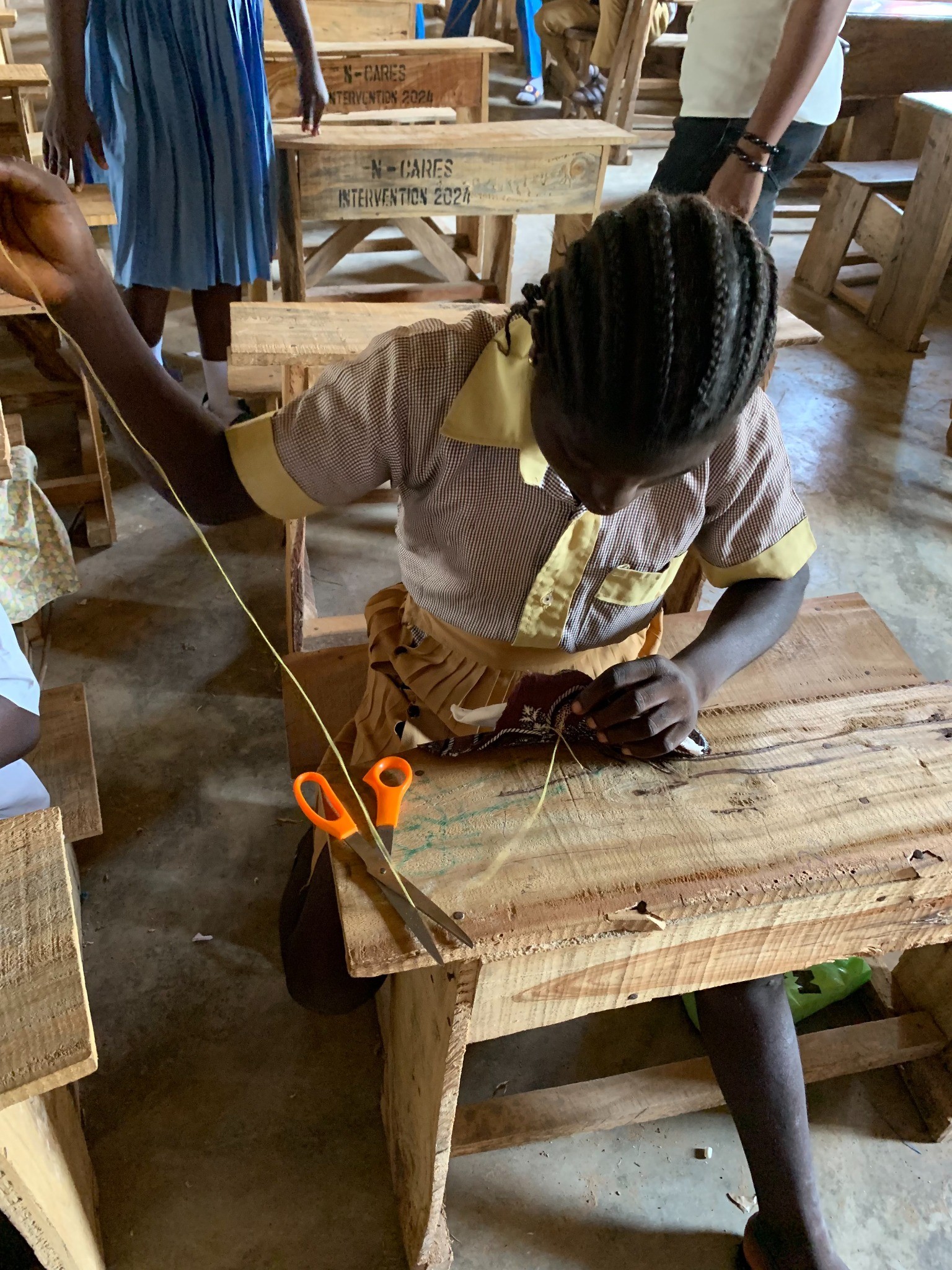 A girl sewing her reusable Pads with needle and thread